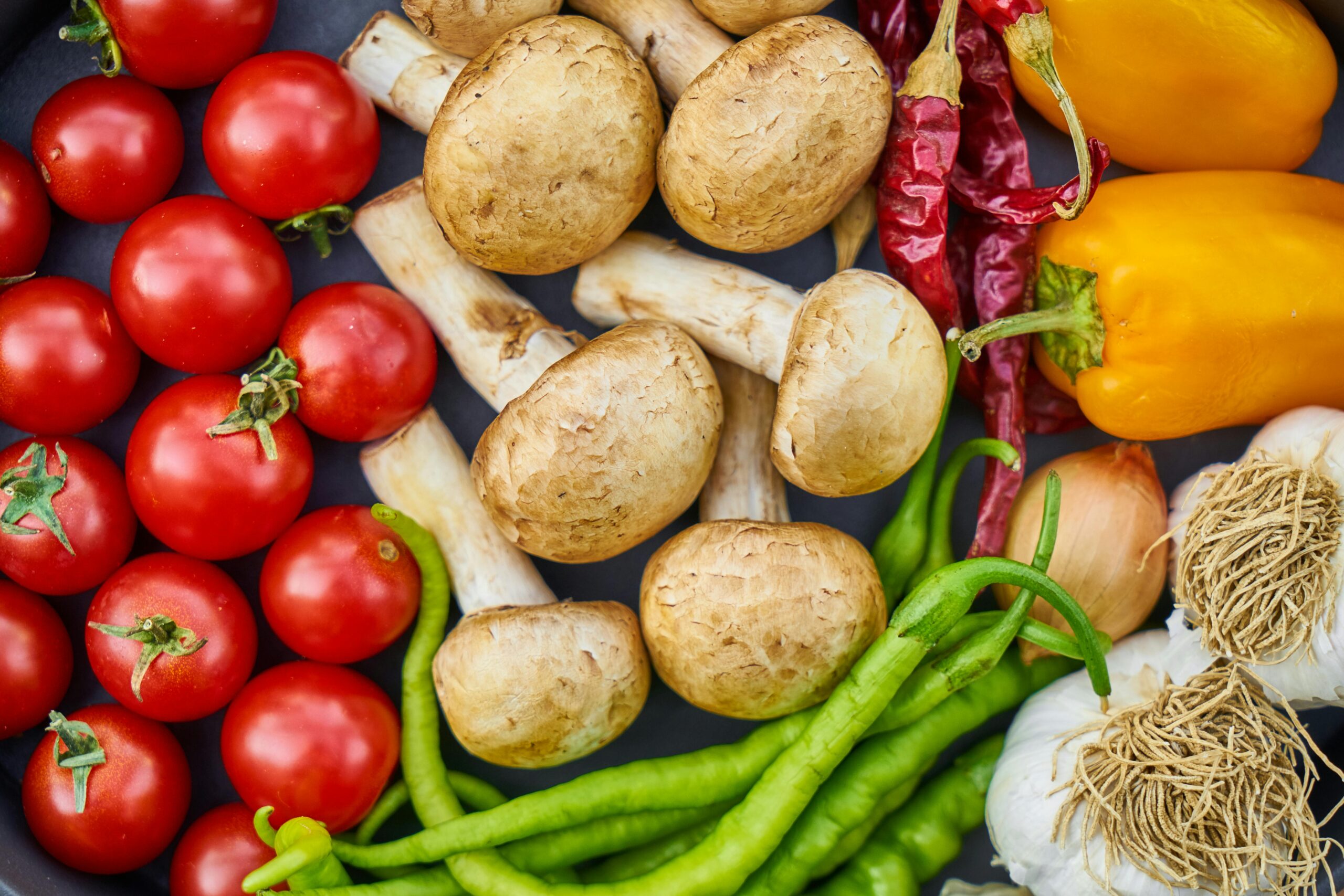 pexels-photo-1435904-1435904 A vibrant assortment of fresh vegetables and mushrooms arranged in a flat lay.